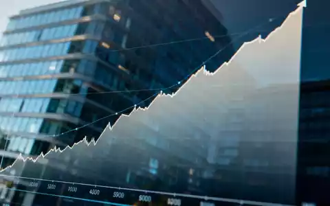 Eine Nahaufnahme eines Finanzdiagramms auf einem Bildschirm mit einem Aufwärtstrend und einer Spiegelung eines modernen Bürogebäudes. - Foto: über boerse-global.de