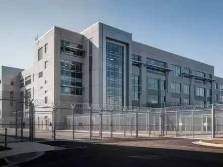 Ein modernes, großes Justizvollzugsanstaltsgebäude mit klaren architektonischen Linien und einem Gefühl von Sicherheit. - Foto: über boerse-global.de