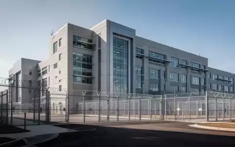 Ein modernes, großes Justizvollzugsanstaltsgebäude mit klaren architektonischen Linien und einem Gefühl von Sicherheit. - Foto: über boerse-global.de