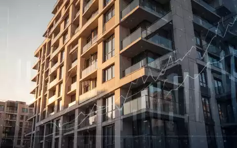 Nahaufnahme eines modernen Wohngebäudes, das Immobilien und Investitionen symbolisiert, mit abstrakten Finanzdaten im Hintergrund. - Foto: über boerse-global.de