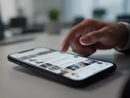 Eine Hand schwebt über einem Smartphone-Bildschirm mit einem unscharfen Social-Media-Feed, der mentale Erschöpfung darstellt. - Foto: über boerse-global.de
