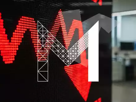 Ein digitaler Börsenticker zeigt rote, fallende Zahlen und einen nach unten zeigenden Pfeil vor einem unscharfen Bürohintergrund. - Foto: über boerse-global.de
