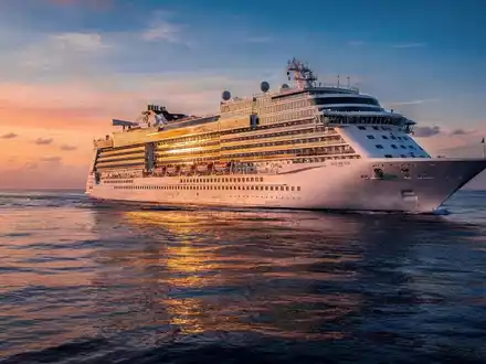 Ein luxuriöses Kreuzfahrtschiff segelt bei Sonnenuntergang auf einem ruhigen, tiefblauen Meer. - Foto: über boerse-global.de
