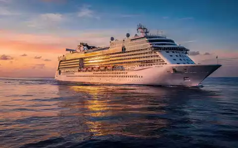 Ein luxuriöses Kreuzfahrtschiff segelt bei Sonnenuntergang auf einem ruhigen, tiefblauen Meer. - Foto: über boerse-global.de