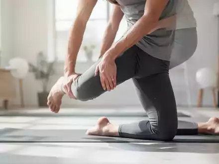Eine Person führt eine Yoga-Übung zur Hüftmobilität durch, die die Hüftregion und die Beine betont. Eine ruhige, therapeutische Szene. - Foto: über boerse-global.de