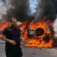 Ein Mann läuft vor brennenden Autos, die bei einem israelischen Luftangriff in der libanesischen Hafenstadt Sidon in Brand geraten sind. - Bild: Mohammed Zaatari/AP/dpa