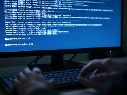 Close-up of a computer screen displaying a blue error message, with blurred hands near a keyboard. - Foto: über boerse-global.de