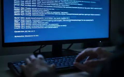 Close-up of a computer screen displaying a blue error message, with blurred hands near a keyboard. - Foto: über boerse-global.de