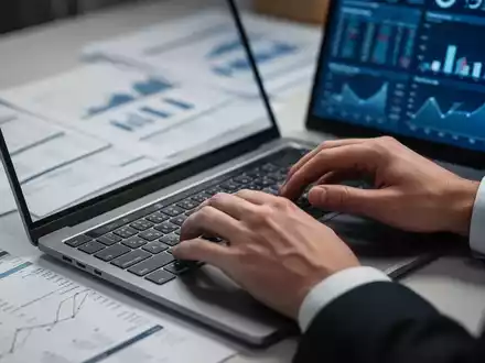 Nahaufnahme von Händen, die auf einer Laptoptastatur tippen, mit verschwommenen Dokumenten und Diagrammen im Hintergrund. - Foto: über boerse-global.de