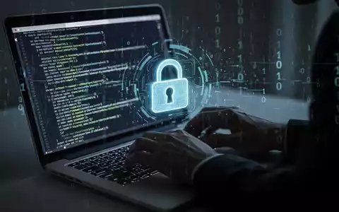 A shadowy figure types on a laptop, code on screen, with a digital lock icon and binary data representing a cybersecurity breach. - Foto: über boerse-global.de