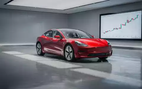 Ein rotes Elektroauto in einem modernen Ausstellungsraum mit einem digitalen Börsenchart, der einen Abwärtstrend zeigt. - Foto: über boerse-global.de