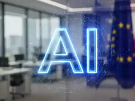 Ein stilisiertes, leuchtendes blaues 'AI'-Symbol über einem subtilen digitalen Wasserzeichenmuster in einem modernen Büro. Fokus auf KI-Kennzeichnung. - Foto: über boerse-global.de