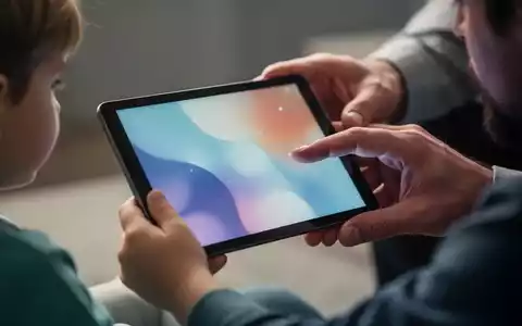 A child's hand holding a tablet with a blurred image, a parent's hand gently guiding it. Illustrates child safety and parental controls. - Foto: über boerse-global.de