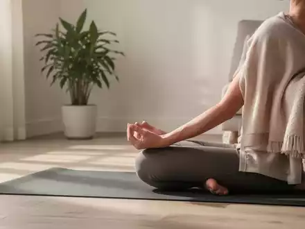 Eine ruhige Innenszene in einem Zuhause, in der eine Person sanft Yoga oder meditiert, umgeben von Elementen der Ordnung und Ruhe. - Foto: über boerse-global.de