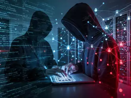 A person in a hoodie typing on a laptop, surrounded by abstract digital code and server racks, symbolizing cybersecurity threats. - Foto: über boerse-global.de