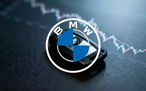 Ein BMW-Autoschlüssel auf dunklem Untergrund, im Hintergrund verschwommen ein fallender Börsenchart. Symbolisiert das 52-Wochen-Tief der Aktie. - Foto: über boerse-global.de