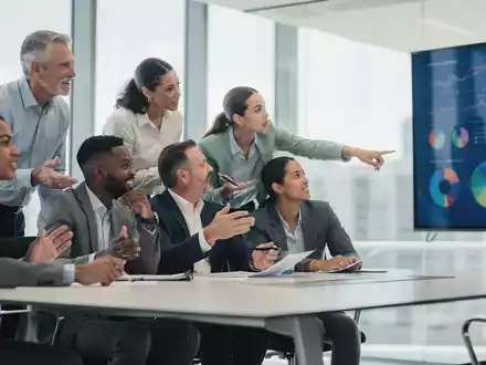 Eine Gruppe von Fachleuten in einem modernen Konferenzraum, die über Finanzdaten und Beschlüsse diskutieren. - Foto: über boerse-global.de