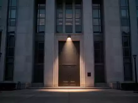 Eine imposante, moderne Regierungsgebäude-Fassade in der Dämmerung, die Sparmaßnahmen und Budgetkürzungen symbolisiert. - Foto: über boerse-global.de