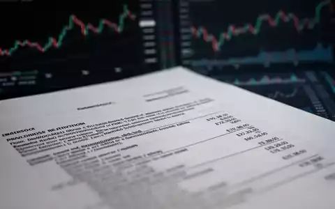 Ein Nahaufnahme eines juristischen Dokuments oder einer Finanzaufstellung mit unscharfem Text im Vordergrund und angedeuteten Börsencharts im Hintergrund. - Foto: über boerse-global.de