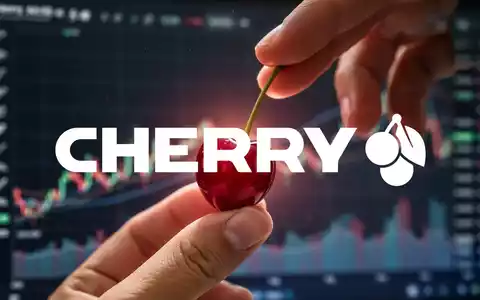 Eine Hand hält eine glänzende rote Kirsche vor einem verschwommenen Hintergrund von Finanzdiagrammen und -grafiken. - Foto: über boerse-global.de