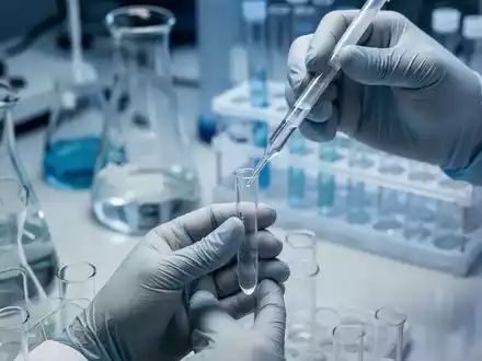 Nahaufnahme der Hände eines Wissenschaftlers, der in einem Labor eine Flüssigkeit in ein Reagenzglas pipettiert, mit verschwommenen Geräten im Hintergrund. - Foto: über boerse-global.de