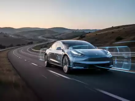 Ein modernes Elektrofahrzeug auf einer kurvenreichen Straße bei Dämmerung, das Geschwindigkeit und fortgeschrittene Technologie vermittelt. - Foto: über boerse-global.de