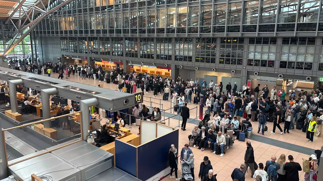 Zahlreiche Menschen stehen im Terminal des Hamburger Flughafens. - Bild: Frank Molter/dpa
