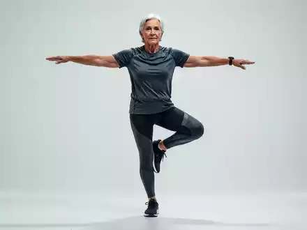 Eine Person in Sportkleidung balanciert auf einem Bein mit ausgestreckten Armen, um das Gleichgewicht zu halten. - Foto: über boerse-global.de
