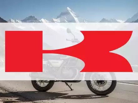Eine neue Kawasaki HIMALAYAN Motorrad auf einer kurvenreichen Bergstraße im Himalaya, mit schneebedeckten Gipfeln im Hintergrund. - Foto: über boerse-global.de