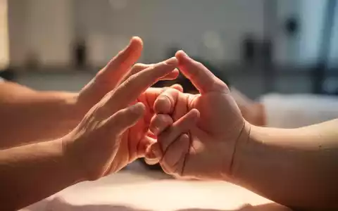 Nahaufnahme von Händen, die Akupressur- oder Fingerübungen durchführen, mit weichem Licht und unscharfem Hintergrund. - Foto: über boerse-global.de