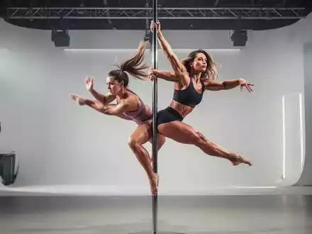 Eine athletische Frau in dynamischer Bewegung an einer Poledance-Stange, die Kraft und Flexibilität demonstriert. - Foto: über boerse-global.de