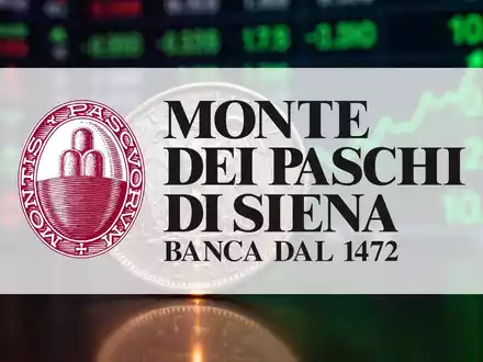 Nahaufnahme einer alten italienischen Münze, die ein leichtes Leuchten reflektiert, mit einem unscharfen Börsenticker im Hintergrund. - Foto: über boerse-global.de