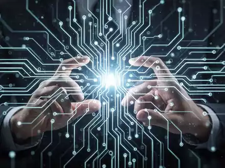 Stylized image of a glowing neural network with hands interacting with a digital interface, symbolizing AI education and technological development. - Foto: über boerse-global.de