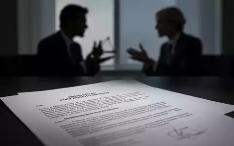 Ein verschwommenes Bild eines Anwalts und eines Mandanten, die sich unterhalten, mit einem fokussierten Rechtsdokument im Vordergrund. - Foto: über boerse-global.de