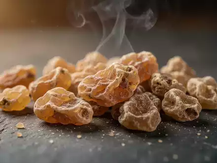 Nahaufnahme von getrocknetem Weihrauchharz, das auf einer dunklen Oberfläche liegt, mit leicht aufsteigendem Rauch, der eine therapeutische Atmosphäre schafft. - Foto: über boerse-global.de