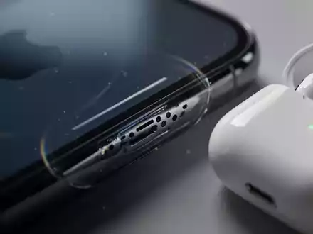 Close-up of an iPhone speaker grille next to an AirPods Pro charging case, illustrating audio technology and device integration. - Foto: über boerse-global.de