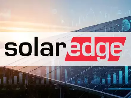 Solarpanels bei Sonnenaufgang mit einer digitalen Darstellung von Finanzdaten im Vordergrund. - Foto: über boerse-global.de