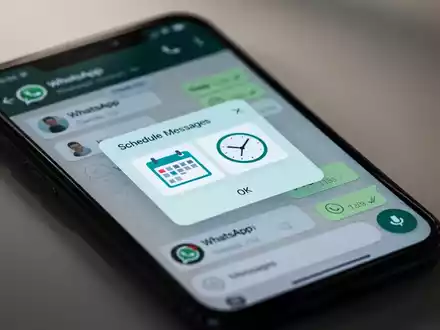 A smartphone screen showing the WhatsApp app with a message scheduling interface open, displaying options for date and time selection. - Foto: über boerse-global.de