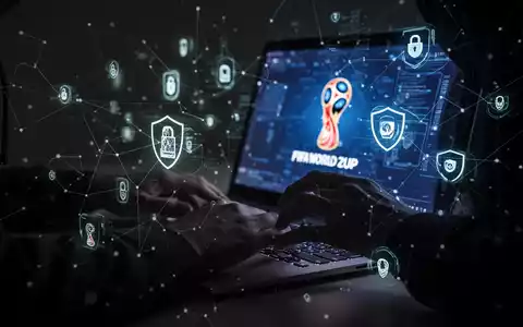 A shadowy figure's hands typing on a laptop, with security icons and network lines, symbolizing online fraud during the FIFA World Cup. - Foto: über boerse-global.de