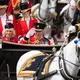 In einer offenen Kutsche fährt das britische Königspaar durch London. - Bild: Kirsty Wigglesworth/AP/dpa