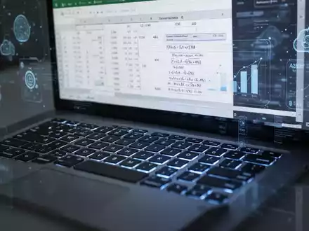 A modern laptop keyboard with glowing keys and an Excel spreadsheet on the screen, showing data and formulas. - Foto: über boerse-global.de