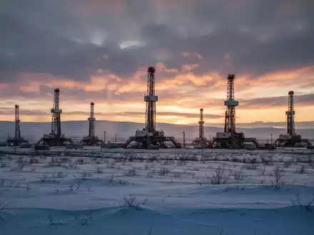 Mehrere Bohrtürme stehen in einer weiten, schneebedeckten Landschaft im Athabasca-Becken bei Sonnenaufgang. - Foto: über boerse-global.de