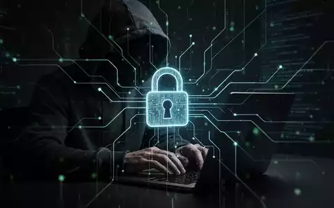 A shadowy figure typing on a laptop, with a digital padlock and glowing data lines, symbolizing cybercrime and security. - Foto: über boerse-global.de