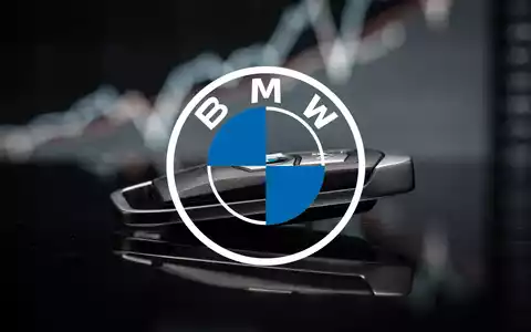 Ein BMW-Autoschlüssel liegt auf einer dunklen Fläche, im Hintergrund eine unscharfe rote Finanzkurve, die fällt. - Foto: über boerse-global.de