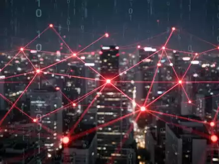 A glowing red digital network overlaid on a blurred city at night, symbolizing AI surveillance and government oversight. - Foto: über boerse-global.de
