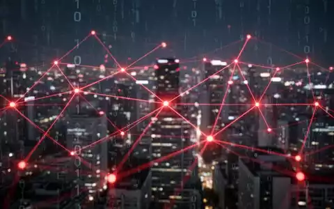 A glowing red digital network overlaid on a blurred city at night, symbolizing AI surveillance and government oversight. - Foto: über boerse-global.de