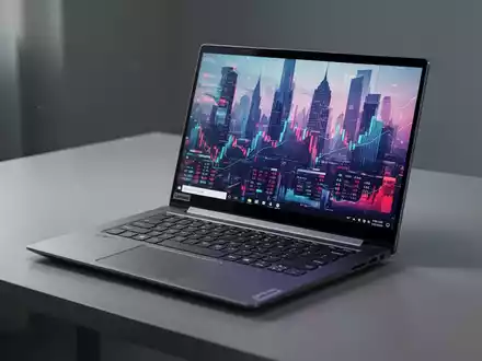 A sleek, modern Lenovo laptop open on a minimalist desk, displaying a vibrant screen with abstract financial data. - Foto: über boerse-global.de