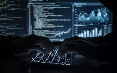 Hände tippen auf einer leuchtenden Tastatur, während im Hintergrund verschwommene Daten und Codezeilen zu sehen sind, die KI-Cyberkriminalität symbolisieren. - Foto: über boerse-global.de