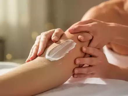 Hände cremen einen Arm ein, mit weichem Licht und einem ruhigen Hintergrund, der Selbstpflege und Entspannung symbolisiert. - Foto: über boerse-global.de