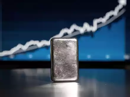 Ein glänzender Silberbarren im Vordergrund, der eine stark steigende Kurskurve auf einem digitalen Bildschirm im Hintergrund widerspiegelt. - Foto: über boerse-global.de